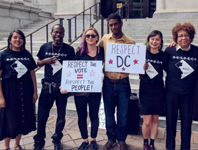 Photo of people with signs saying 'Respect the people', Respect DC'